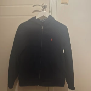 Polo Ralph Lauren zip hoodie  - Säljer denna hoodie från kidsbrandstore med märket Ralph Lauren då den har blivit för liten för mig. Använd 2 gånger, är i storlek L(14-16). Den är i bra skick och säljer denna för 950kr