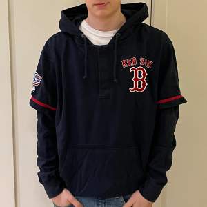 En mörkblå hoodie från 47 i storlek large, L. Det står Red Six B på tröjan, vilket är ett amerikansk basebollag. Kvaliten är bra.