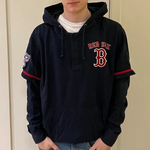 Amerikansk hoodie - En mörkblå hoodie från 47 i storlek large, L. Det står Red Six B på tröjan, vilket är ett amerikansk basebollag. Kvaliten är bra.
