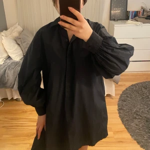 Skjorta  - Svart skjorta med ballongärm från Second Female. På hösten/vintern har jag använt den tillsammans med jeans eller skinnbyxor. Och på sommaren har jag använt den som klänning med cykelbyxor under. Normal i storlek. Nypris 1299kr