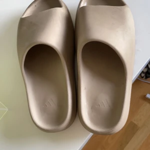 Yezzy slide - Hej! Säljer du mina yezzy slide (pure) pågrund av att jag ej använder dem mera. Dem är i väldigt bra skick pågrund av att de är sparsamt använda. Storleken är 46 men de passar 44 - 44.5. De kommer med original box och är köpta på stockX.