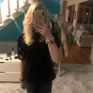 Svart festtopp - Säljer denna superfina glittriga svarta puffärmade festtopp/ blus med paljetter🥰🥰 Har använts några gånger och är i väldigt bra skick👌👌💗💞