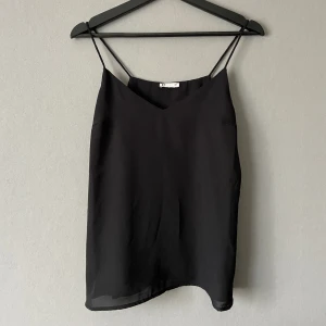 Svart linne blus - Blus från Cubus i två lager, den övre mer skir. Felfri och nästintill oanvänd. Längd från axel ner: 62 cm. Byst bredd: 43cm. Polyester tyg och 40° tvätt. 