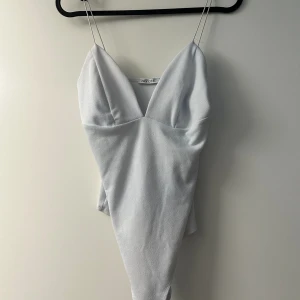 Vit body - En vit body som i tvätten fått en lite ljus nyans av blå. Säljer den billigt.