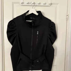 Jacka - En jacka med bälte i midjan 