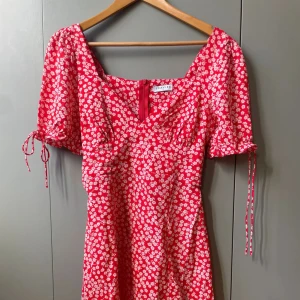 Röd miniklänning med vita blommor - Röd miniklänning med vita blommor från Loavies, oanvänd ❤️ Första bilden är lånad 🍄