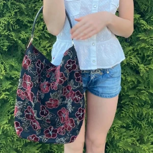 Väska - Verkligen så fin och unik blommig vintage väska med blommor i velvet (sammet) material och små insydda glansiga pärlor som reflekterar i färgerna. Jättefina detaljer och äkta läder på handtaget! Mycket utrymme på insidan!  Skicket är som nytt!💋