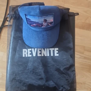 Två revenite kepsar - Två väldigt snygga trucker kepsar i färg blå och grå. Den blåa har tyvärr ett litet hål men inte så synligt. Inget problem med den gråa. 190 för den blåa och 210 för den gråa. Går att pruta ner 