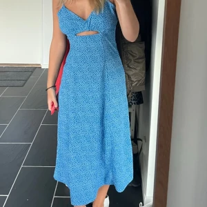 Blommig klänning  - Säljer denna sköna blåa klänningen med vita blommor på ifrån Bikbok! Använd få gånger men är i nyskick🥰