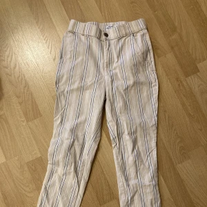 Randig hollister byxor - Randig byxor från Hollister i beige, vit och blå. Storlek XS