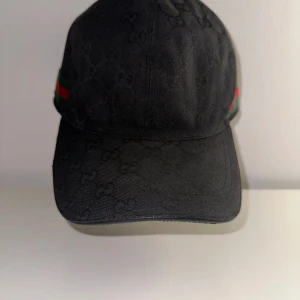 Gucci keps svart storlek L/XL (60) - Säljer nu min Gucci keps som är i fint skick. Kepsen är i storlek XL men sitter som en L.  Säljer pga att jag inte har någon användning av den och den ligger bara hemma och dammar. Självklart äkta.