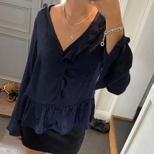 Mörkblå blus med volanger  - Mörkblå volangblus från NA-KD i storlek 38, passar S och M. Fint skick. Använd gärna köp nu!