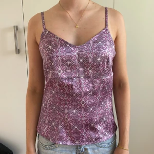 Lila topp - Säljer denna superfina lila mönstrade toppen då den inte kommer till användning💓den har justerbara axelband och en dragkedja på sidan. Storlek 38 men sitter mer som en S💌tveka inte om ni har några frågor!!