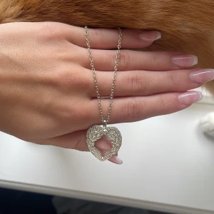 Skit snyggt Halsband - Säljer detta jätte fina glittriga silvriga halsbandet med två ängla vingar som är så fint! Säljer pga jag inte använder silver längre