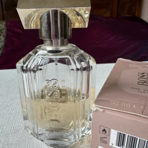 Parfym Hogo Boss the scent - Essenser av förförisk fresia och läckert söt persika råder över denna Eau de Parfums inledande toner.