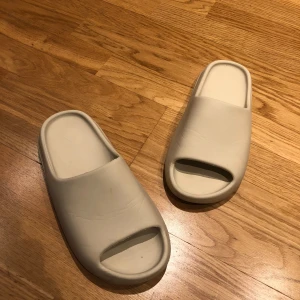 Yeezy Slides - Säljer mina Yeezy Slides som jag fick som en gåva av en vän, produkten är i väldigt bra skick och är i storlek 42. Perfekta nu för sommaren, och priset kan diskuteras vid snabb affär.