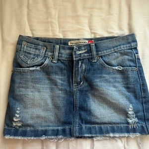 Kort kjol - Kjolens skick är helt okej eftersom dragkedjan på kjolen har gått sönder. Har försökt att fixa det med en säkerhetsnål. Kjolens midjemått är 76 cm.