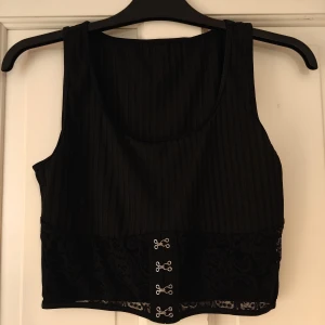 Svart kort topp  - Svart kort topp med detaljer  Spetsen på framsidan är genomskinlig  Aldrig använd