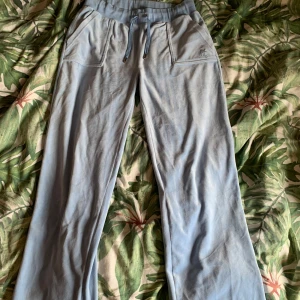 Juicy byxor - Ljusblåa juciy byxor i storlek M. Knappt använda men uppsydda längst ner på benen för att passa mig som är 165cm (syns ej när man använder dem). Annars i väldigt gott skick.