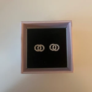 Silver örhängen  - Jag säljer ett par silverpläterade örhängen i form av sammanflätade ringar med vackra kristaller från Pilgrim. Örhängena är bly och nickelfria, nypriset är 249kr😁 Örhängena är sparsamt använda och är helt intakta. Hör av dig ifall du har några frågor
