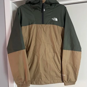 THE NORTH FACE Jacka. - Vindjacka ifrån The north face. Olivgrön och beiga. Storlek: Junior L  Fint använt skick, knappt använd.