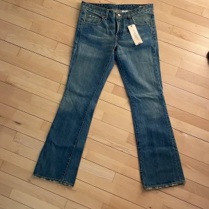 Levis jeans - Levis jeans, låg midja, boot cut. Modellen har en sliten look med fransar nedtill. Oanvända 