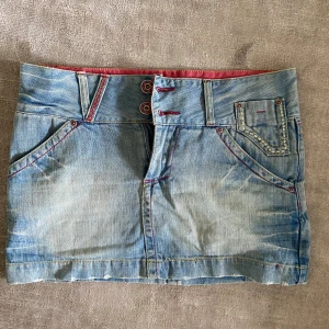 Lågmidjad jeanskjol - Lågmidjad jeanskjol från ONLY med röda detaljer. Storlek 38. Super skick. Kolla gärna in mina andra annonser!! PS Är inte hemma men kommer tbx den 23e juli