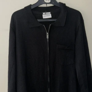 Merinoull J Lindbergh Cardigan - Svart Merinoull J Lindbergh Cardigan storlek S. Använd en gång nykvalitet