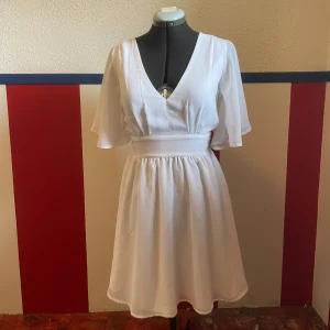 Vit klänning - Jätte fin vit flowy klänning som jag hade till min student förra året! Liten smutsfläck på ena ärmen som borde gå bort i tvätten.  Broderi som jag gjort på banden. De går lätt att sprätta bort om du inte vill ha kvar dem, eller behåll dem!