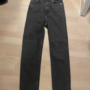 Svarta / mörkgrå jeans från weekday i modell ROWE storlek W24 och längs som passar mig på 170 cm. Har en slit och uppklippt hem.