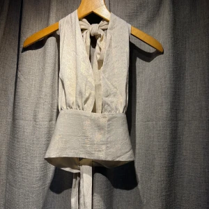 Topp Obsession  - Top från Obsession STHLM Trendig och väldigt snygg till sommaren.  Använd ca 2 gånger! Storlek: Onesize men skulle säga att den passar en xs-m beroende på hur hårt man knyter i midjan och nacken.