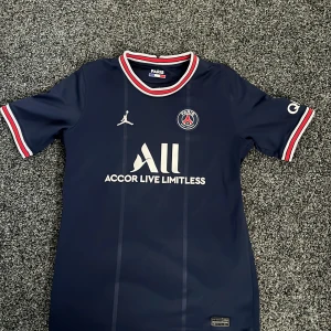 PSG tröja storlek 158-170 XL  - Säljer den här skitsnygga PSG tröjan. Den är sparsamt använd bara någon liten defekt som du kan se på bild 4. Den syns inte när tröjan är på. Köpt från PSG,s hemsida för 1200kr. Pris kan diskuteras.