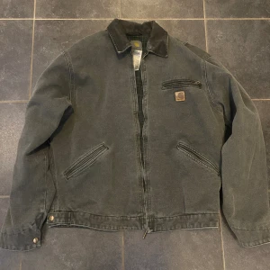 Carhart Detroit Jacket - Säljer denna feta Carhart jackan. Den är i 10/10 skick och knappt använd! Super bra kvalitet med många fickor! Den är i storlek L men är ganska liten i storleken👍Pris kan diskuteras!
