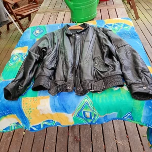 Skinnjacka svart stl XXL Scanfilr. - Äldre svart skinnjacka Scanfilr stl xxl knäppes med dragkedja och knappar.innefoder polyester ,nylon. Hängt i ett förråd och bör tvättas .I övrigt fint skick.