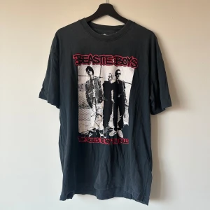 Graphic Beastie Boys t-shirt i storlek M. - Cool grå t-shirt med tryck både på framsidan och baksidan. Storleken är lite oversized och är mellan M/L. Varsamt använd och legat i garderoben senaste tiden!