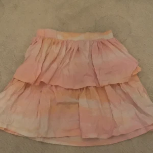 Kort volangkjol  - En rosa/orange kjol, endast använd ca 5 gånger. 