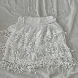 Vit kjol - Luftig vit kjol med detaljer, köptes utomlands utan märke! Passar alla mellan S-L eftersom den är stretchig! I bra skick 