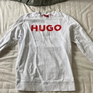 Hugo tröja - Säljer min Hugo tröja i storlek M, väldigt svaga små fläckar på framsidan som går att tvätta bort. Inga andra defekter då den knappast används. Normal passform.