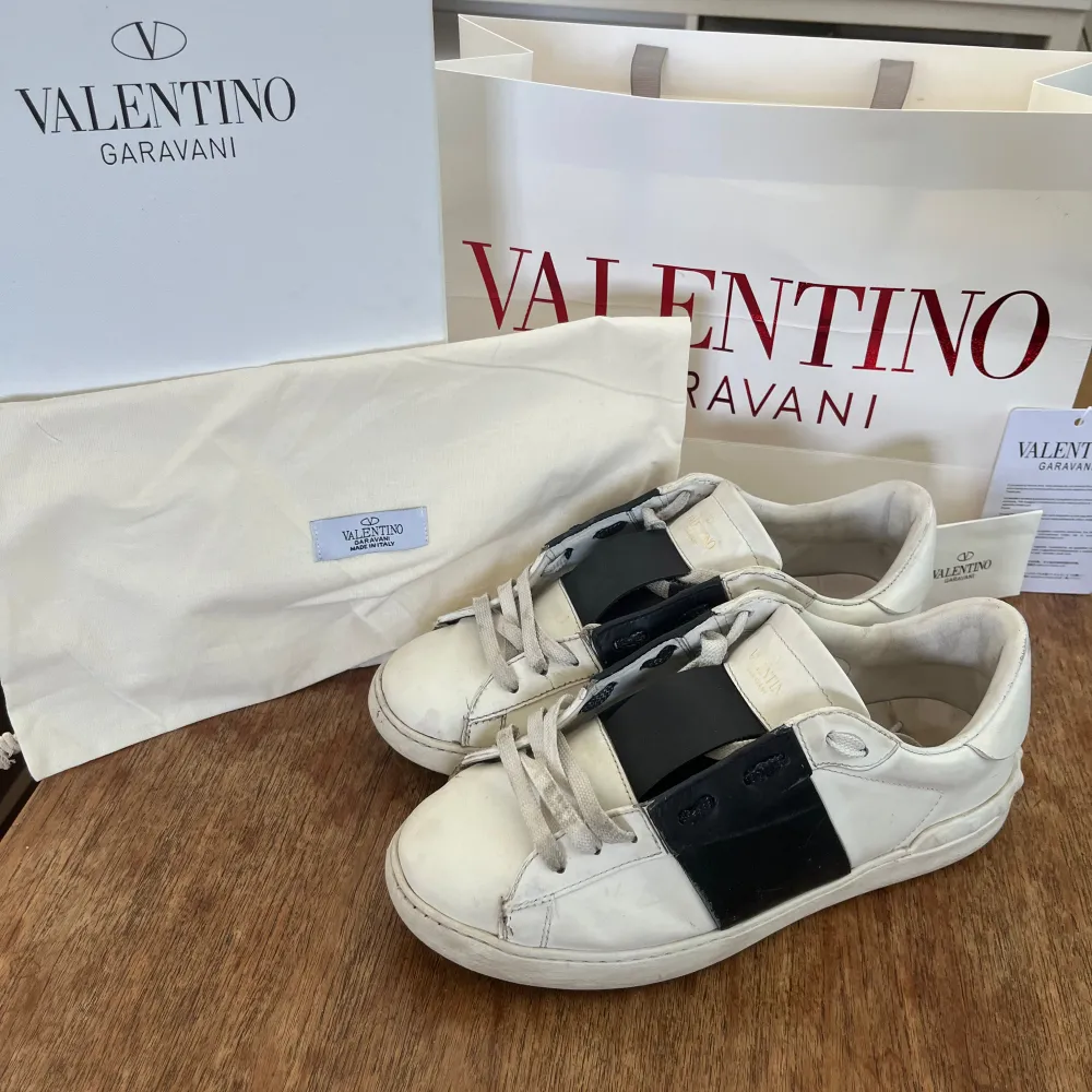 Ett par vita Valentino Garavani open sneakers. Skorna har en klassisk design med en låg profil och är tillverkade i skinn. ⚠️Allt i bilden ingår⚠️. Skor.