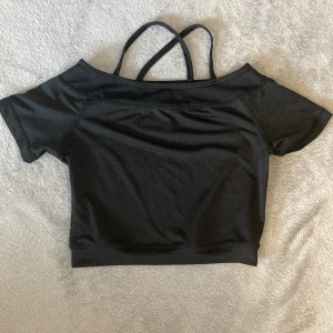 Träning magtröja  - På tredje bilden ser man hur det är ett lite mer genomskinlig tyg. Banden gör så att det blir som ett kryss på ryggen 