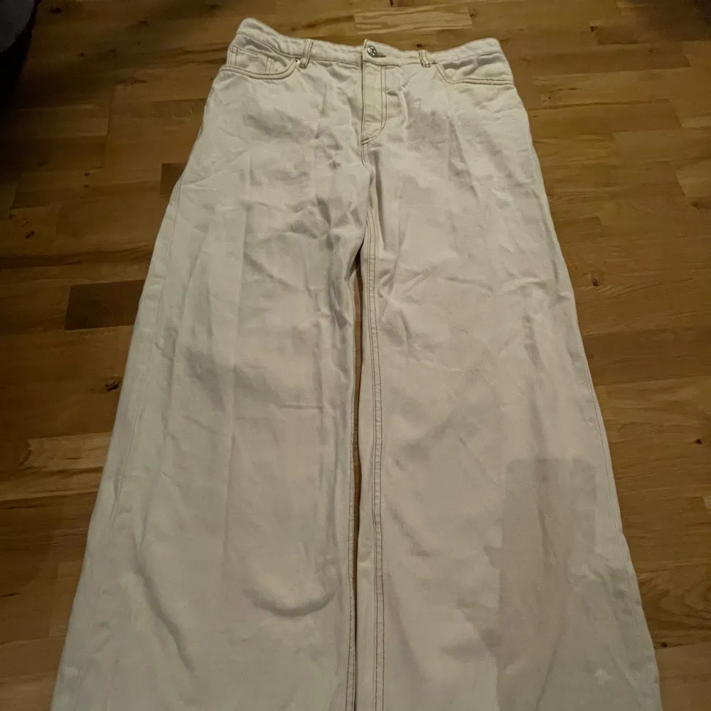 Vida jeans med normalhög midja. Färgen är äggskalsvit med orange/bruna sömmar. Uppsydda för att passa mig som är 165 cm. Använda ett antal gånger men är i fint skick. Storlek 31, passar bra för storlek M.. Jeans & Byxor.