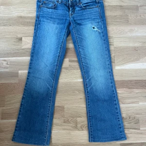 Blå jeans från American Eagle  - Blå jeans med låg midja i bra skick från American Eagle. Jag säljer se på grund av att de inte passar mig längre. Passar storlek 34/36 och de har varit uppsydda för att passa mig (158cm).