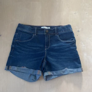 Jeans shorts - Jeansshorts som är washed och mörkblå från name it i strl 152/ xxs/xs. Jätte fina medelhöga jeansshorts i ett jätte bra skick. De är strechiga så den kan säkert passa xs med.