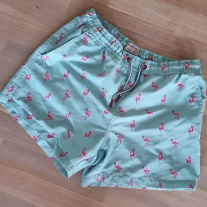 Badshorts Flamingos - Snygga badshorts med rosa flamimgos. Fint skick. Med innerbyxa.