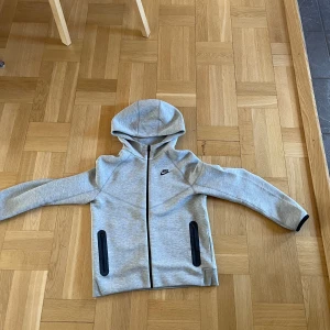 Den nya Nike tech grå  - En grå Nike tech som är i ny skick andvänd några gånger storlek XL i barn men också 158-170 CM kan tänka mig att sänka lite vid snabb affär jag kan bara mötas 