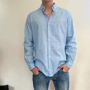 ralph lauren - Blå ralph lauren skjorta i bra skick. Storlek 34/35 (16,5) vilket motsvarar ca L-XL. Modellen är 186 cm lång. Originalpris ca 1500 kr och nu endast för 499 kr.