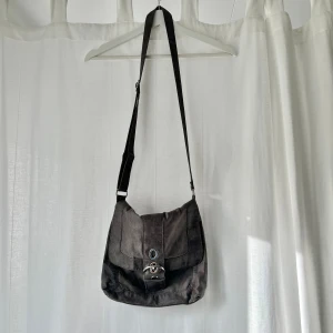 Grå axelremsväska - Grå axelremsväska med justerbart snöre. Bredd: 25 cm. Djup: 5 cm. Höjd: 29 cm 💞