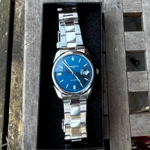 Ljusblå Chronos klocka - Säljer en sprillans ny klocka i väldigt gott skick och fungerar utmärkt. Skriv i dm för mått eller pris förslag