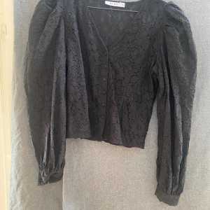 Spetsblus - Svart spetsblus mer knappar och v-ringning  Puffärm i nyskick