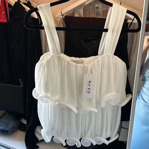 Vit volang topp - Super fin volang topp från Lovisa Wallins kollektion med NA-KD, aldrig använd med lappen kvar! Katt finns i hemmet🐈‍⬛